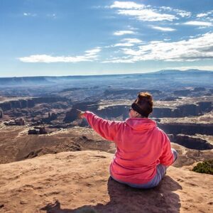 Woman pointing overlooking canyons