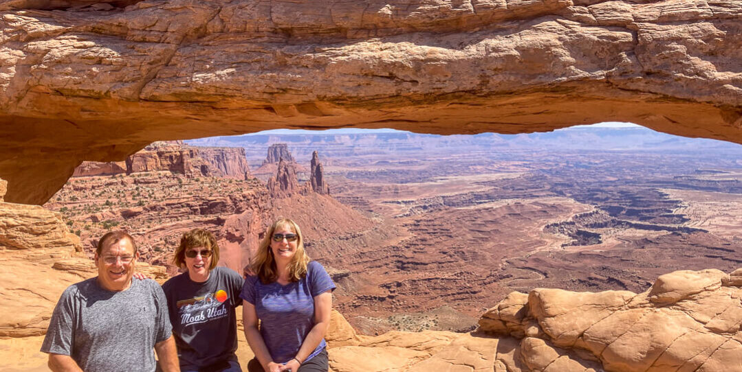 people sitting at mesa arch